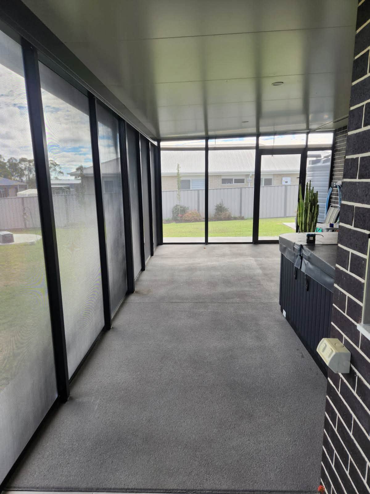 Fully screened alfresco patio enclosure with black frames